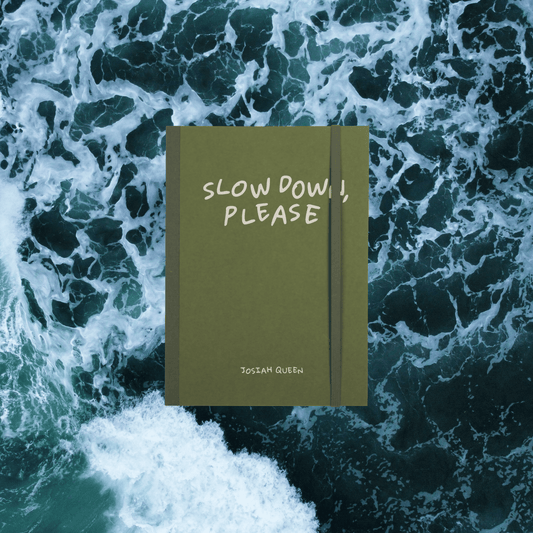 Green Notebook with 'Slow Down, Please' Josiah Queen text , elastic bungee page holder on a background of ocean waves