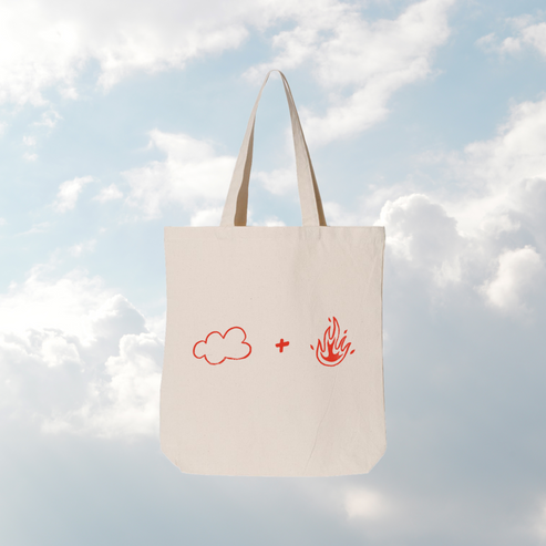 Tote bag with cloud and fire symbols against a cloudy sky background