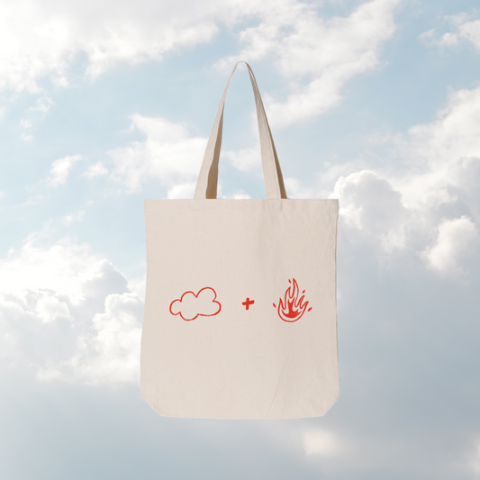 Tote bag with cloud and fire symbols against a cloudy sky background